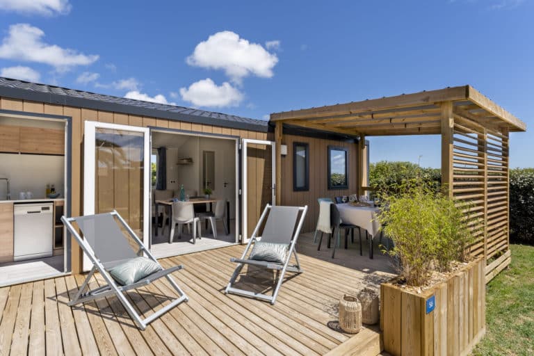 Terrasse ensoleillée d'une maison en bois.