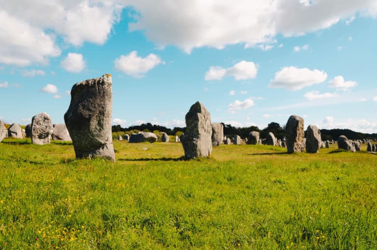 Alignements de menhirs en Bretagne sous ciel bleu.