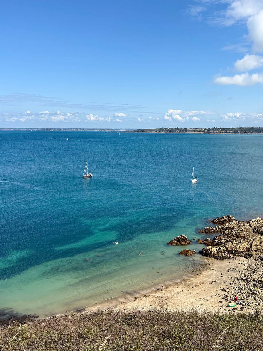 Plage de sable avec voiliers et ciel bleu