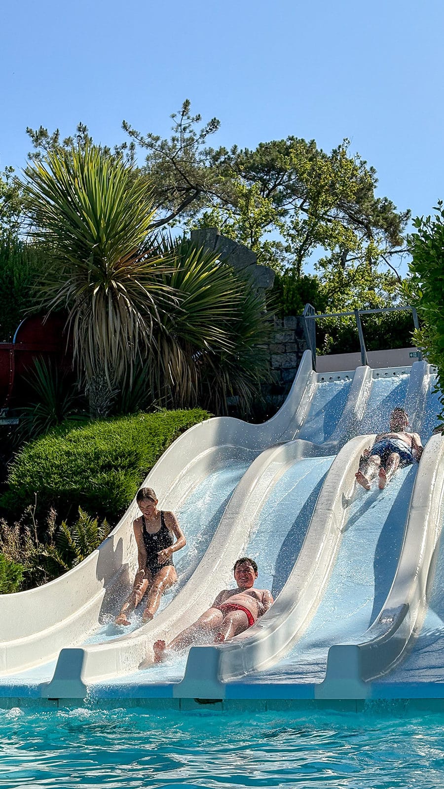 Personnes glissent sur toboggans aquatiques en plein air.