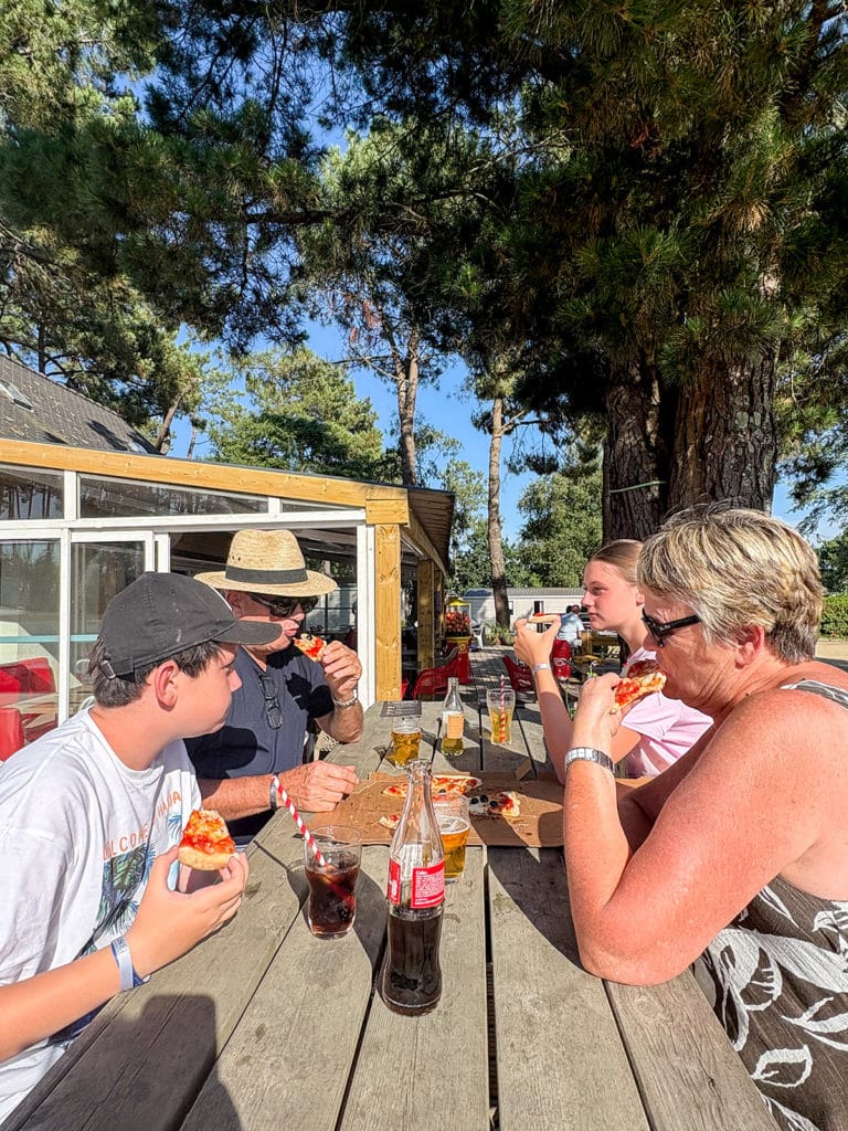 Famille qui mange une pizza en terrasse de restaurant du camping Le Fort Espagnol