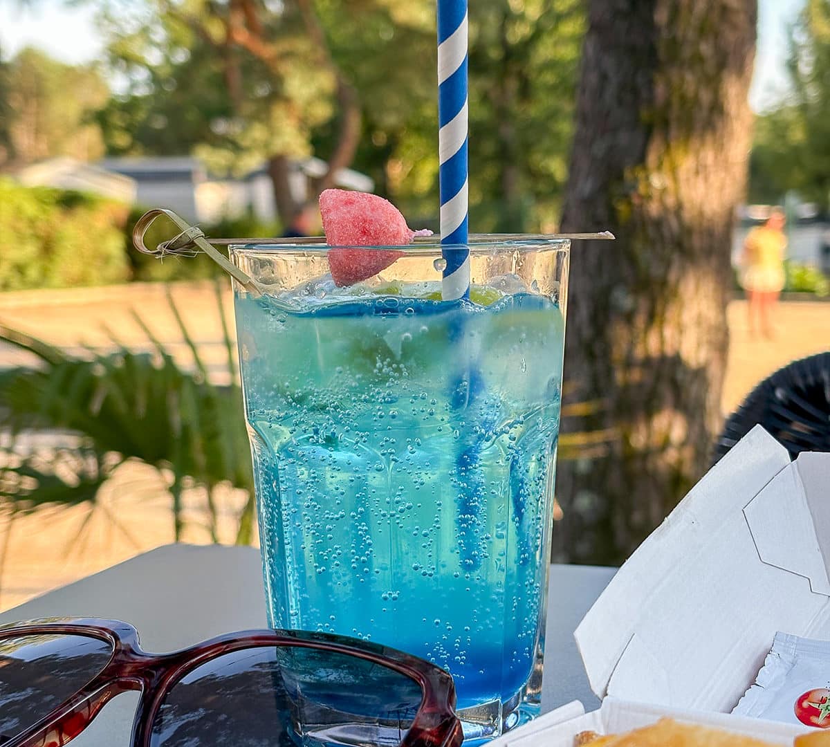 Boisson bleue pétillante avec frites et lunettes.