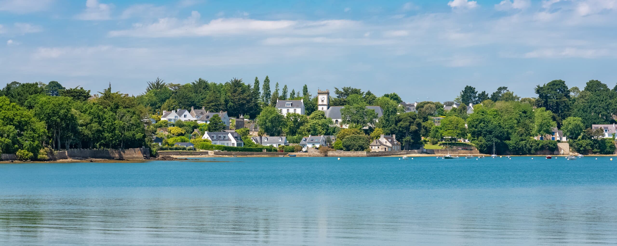 Village côtier tranquille avec église et arbres verdoyants