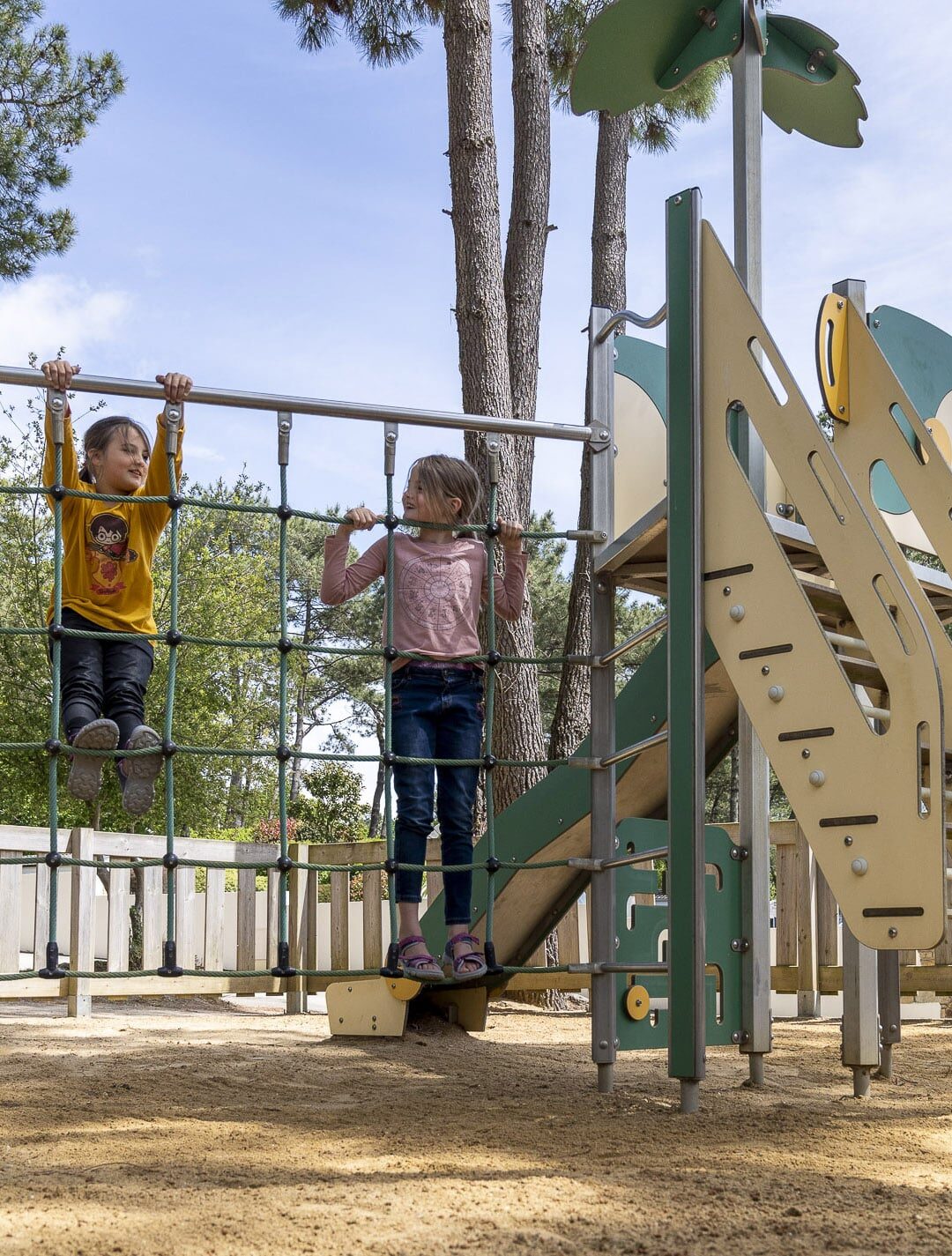 Enfants jouant sur une aire de jeux extérieure.